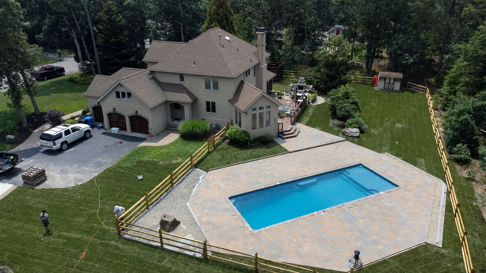 Aerial view of a finished fiberglass pool, patio and landscaped backyard