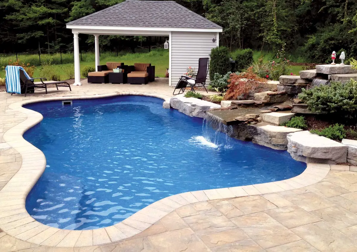 Cape Cod 16 rectangle fiberglass pool installed in a landscaped backyard